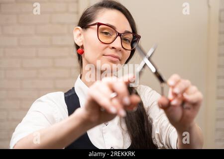 Eine Friseurin, die eine Friseurschere in der Hand hält Stockfoto