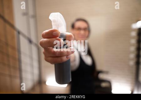 Junge Friseurin mit einem Spray in der Hand Stockfoto
