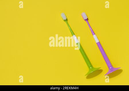 Zwei Kunststoffzahnbürsten auf gelbem Hintergrund, Mundhygiene Stockfoto