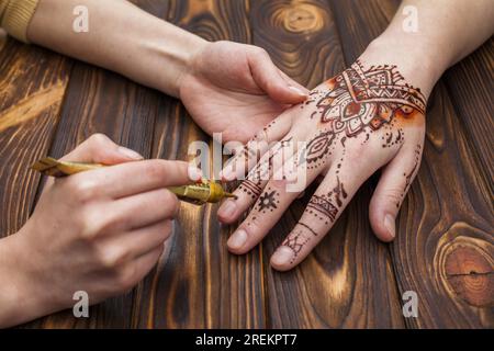 Künstler macht Mehndi-Frauen Hand. Auflösung und hochwertige Fotos Stockfoto