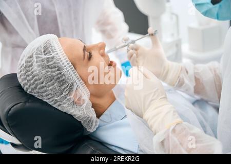 Frau in der Zahnarztpraxis erhält eine Injektion mit Schmerzmittel Stockfoto