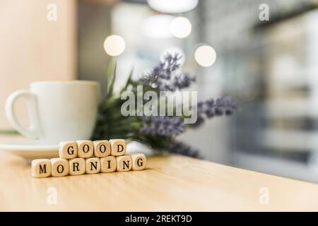 Guten Morgen, Kubikblöcke mit Tasse Kaffee, Holzschreibtisch. Auflösung und hochwertige Fotos Stockfoto