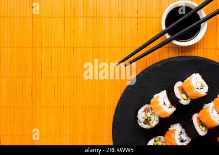 Flache Sushi-Anordnung orangefarbene Bambusmatte. Schönes Foto Stockfoto