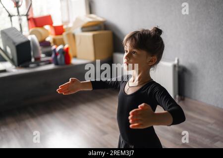 Kindermädchen im schwarzen Sportkörper im Tanzstudio während der Trainingshaltung. 4 5 Jahre Vorschulalter. Gesunde körperliche Entwicklung Stockfoto