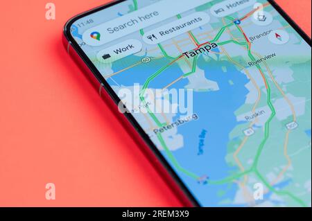 New York, USA - 21. Juli 2023: Autoverkehr auf Tampa google Maps auf Smartphone-Bildschirm Nahaufnahme mit rotem Hintergrund Stockfoto