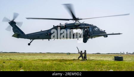 Staff Sgt. Jacob McKague und Paul Bartholdson, 920. Logistics Readiness Squadron Rescue Riggers, bereiten Sie sich darauf vor, während des Trainings zum Tragen von Hebegurten am Patrick Space Force Base, Florida, am 25. Juli 2023 einen Schubanhänger unter einem HH-60G Pave Hawk Helikopter anzubringen. Eine Traglast wird verwendet, um verschiedene Arten von Fracht an abgelegene Orte zu transportieren oder um Sendungen in raue Umgebungen zu beschleunigen, während sie unter dem Pave Hawk Helikopter HH-60G hängen. Der Prozess erfordert eine präzise Abstimmung zwischen dem Flugpersonal und dem Bodenpersonal, um Fracht sicher zu laden und zu entladen. Der 920. LRS bietet logistische Unterstützung für den 920 Stockfoto