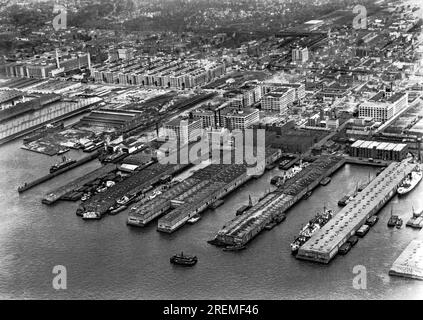 New York, New York: ca. 1935 Brooklyns Docks erstrecken sich in den Hafen, wie auf dem Luftfoto gezeigt. Brooklyns Hafen war einer der geschäftigsten im Land und liegt strategisch am East River in New York. Stockfoto