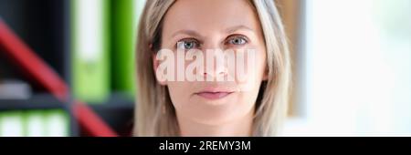 Nahaufnahme einer blonden Frau mittleren Alters, die in die Kamera schaut. Stockfoto