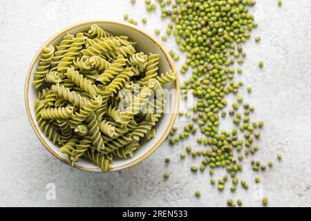 Mungbohnen-Fusilli-Pasta. Schüssel mit roher Pasta und grüner Mungbohne. Glutenfreie Nudeln. Stockfoto