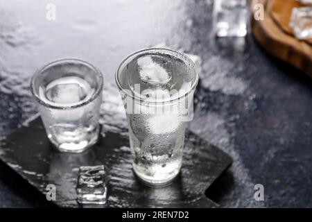 Gehen Sie an Bord mit Wodka-Shots auf einem dunklen Tisch Stockfoto