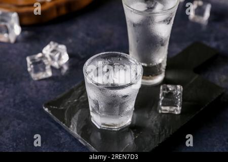 Gehen Sie an Bord mit Wodka-Shots auf einem dunklen Tisch Stockfoto