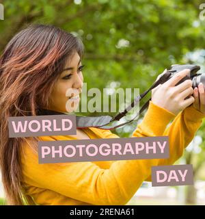 Text zum Weltfotografietag auf Braun über glückliche asiatische Frau mit Kamera im Park Stockfoto