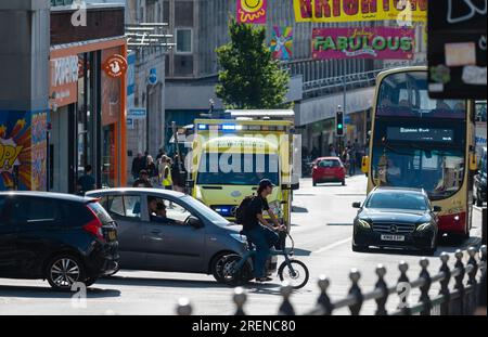 NHS Notarztwagen im Verkehr in einer geschäftigen Stadt, mit blauen Lichtern blinkend, Reise zu einem Notfall in Brighton & Hove, England, Großbritannien. Stockfoto