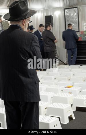 Orthodoxe jüdische Männer beten auf Tisha B'Av, einem Feiertag mit Trauerritualen, einschließlich Sitzen auf niedrigen Stühlen. In Monsey, Rockland County, New York. Stockfoto