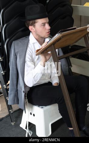 Bei Tisha B'AV Services beobachtet ein junger Mann die trauernden Aspekte des Tages, indem er fastet, auf einem niedrigen Sitz sitzt und keine Lederschuhe trägt. In Rockland. Stockfoto