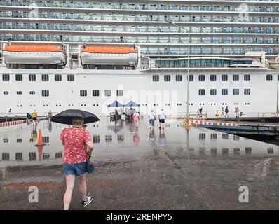 Menschen, die am Kai in Richtung eines großen britischen Kreuzfahrtschiffes auf den Westindischen Inseln im Regen im Januar 2023 gingen Stockfoto