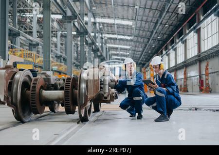 Ingenieurteam, das den Wartungsservice repariert, Triebwerksrad im Lokomotivzug-Reparaturdepot austauschen. Stockfoto