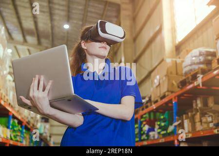 Intelligenter Arbeiter, der ein digitales VR-Gerät mit moderner fortschrittlicher Technologie zur Steuerung des Betriebs verwendet, verwaltet das Lager für Industrieprodukte Stockfoto