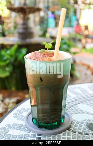 Ein köstliches Glas Iced Mint Cocoa Latte, isoliert auf dem Tisch Stockfoto