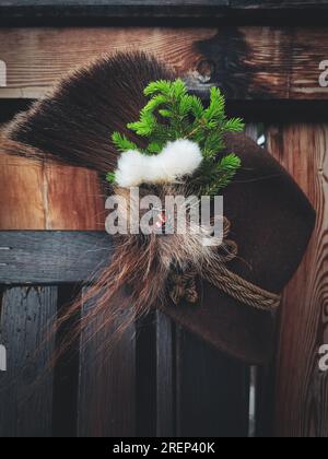 Ein traditioneller Jagdhut mit Chamoishaar, ein Fichtenzweig und Baumwollblumen nach der Jagd Stockfoto