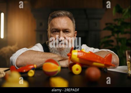 Porträt eines nachdenklichen Senior-Geschäftsmannes mit Spielzeug in Ruhe Stockfoto