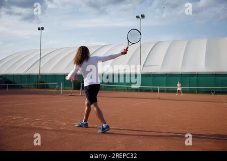 Junge Sportlerin und Tennisspieler auf dem Freiluftplatz Stockfoto