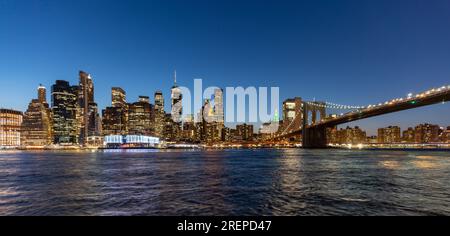 New York Citys Brooklyn Bridge und die Skyline von Manhattan bei Nacht beleuchtet Stockfoto