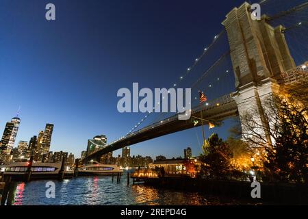 New York Citys Brooklyn Bridge und die Skyline von Manhattan bei Nacht beleuchtet Stockfoto