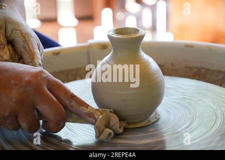 Die Hände der Frau, die einen Keramikbecher auf dem Töpferrad machen Stockfoto