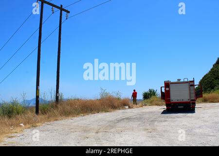 Griechischer Feuerwehrmann auf der Suche nach neuen Waldbränden von der Bergspitze in Troumpeta, Korfu Stockfoto