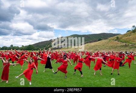 Edinburgh, Schottland, Großbritannien. 29. Juli 2023 Dutzende Frauen in roten Kleidern treffen sich im Holyrood Park, um zu tanzen und den alljährlichen „Most Wuthering Heights Day“ zu feiern – eine Hommage an die Musik von Kate Bush. Iain Masterton/Alamy Live News Stockfoto