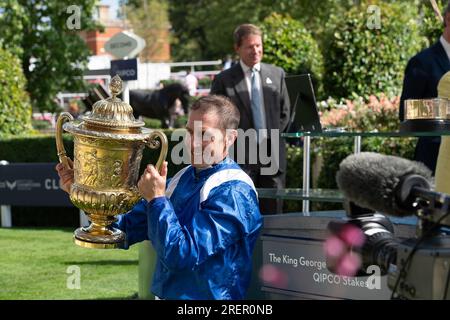 Ascot, Berkshire, Großbritannien. 29. Juli 2023. Jim Crowley hält die Trophäe hoch, nachdem er das King George Rennen gewonnen hat. Prinzessin Anne, die Prinzessin Royal, präsentierte den Besitzer, Trainer und Jockey für die Einsätze King George VI. Und Queen Elizabeth QIPCO. Das Rennen gewann das Pferd Hukum, das von Jockey Jim Crowley geritten wurde. Scheich Hissa und ihr Mann Scheich Maktoum bin Majid Al Maktoum erhielten die Trophäe von der Prinzessin Royal. Eigentümer und Breeder Shadwell Estate Company Ltd Trainer Owen Burrows, Lambourn. Kredit: Maureen McLean/Alamy Live News Stockfoto