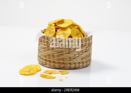 Kerala-Chips oder Banana-Chips, kultiges Snackstück von Kerala, in einem kleinen Korb angeordnet, traditioneller Stil, isoliertes Bild mit weißem Hintergrund Stockfoto