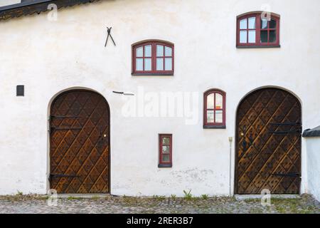 Historische Holztüren und -Fenster an einer weißen Steinwand. Kathedrale von Porvoo, Finnland. Stockfoto