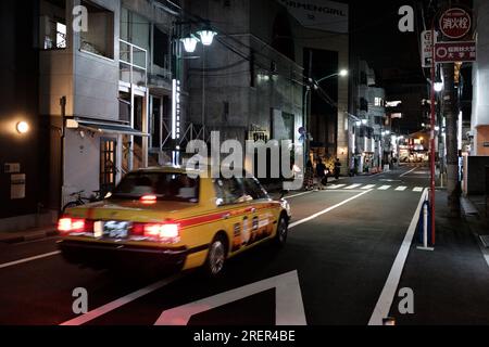 Taxi in Tokio bei Nacht - Ein gelbes Taxi fährt in der Sommernacht in Tokio, Japan Stockfoto