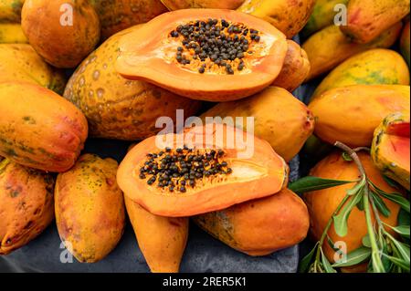 Frische, reife Papaya-Früchte auf einem Holztisch auf dem Straßenmarkt, Nahaufnahme mit Bio-Papaya Stockfoto