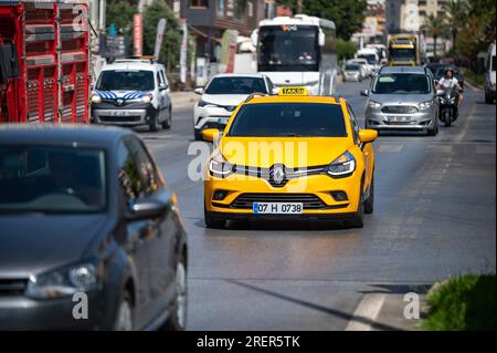 Alanya, Antalya, Türkei. 15. juli 2023 Ein gelbes Taxi fährt die Straße hinunter unter unter dem Verkehr. Stockfoto