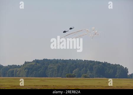 Militärhubschrauber, die sich der Luftverteidigung entziehen. Ein Helikopter setzt Hitzefallen frei, um einer Luftabwehrrakete zu entkommen. Militärluftfahrt auf einer Kampfsorte Stockfoto