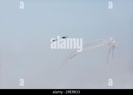 Militärhubschrauber, die sich der Luftverteidigung entziehen. Ein Helikopter setzt Hitzefallen frei, um einer Luftabwehrrakete zu entkommen. Militärluftfahrt auf einer Kampfsorte Stockfoto