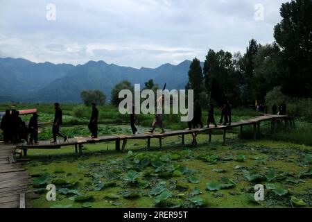 Srinagar Kaschmir, Indien. 28. Juli 2023. Schiitische muslimische Trauernde gehen auf einer hölzernen Fußbrücke rüber, während sie an einer Muharram-Prozession am neunten Tag von Ashura im Inneren des Dal Lake in Srinagar teilnehmen. Ashura ist eine Zeit der Trauer im Gedenken an das Martyrium von Propheten Muhammads Enkel Imam Hussein im siebten Jahrhundert, der 680 v. Chr. in der Schlacht von Karbala im modernen Irak getötet wurde. Am 28. Juli 2023 in Srinagar Kaschmir, Indien. (Kreditbild: © Firdous Nazir/Eyepix via ZUMA Press Wire) NUR REDAKTIONELLE VERWENDUNG! Nicht für den kommerziellen GEBRAUCH! Stockfoto