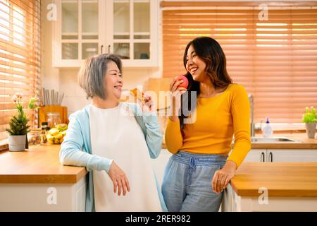 Glückliche Familie Großmutter mit Tochter Porträt. Fröhliche Familie in der Küche, die zusammen lächelt. Stockfoto