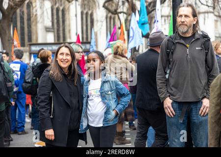 London, Großbritannien -22.04.2023, The Big One Demonstration. Mann, Frau und Mädchen schauen auf ein Poster für die Rettung der Umwelt Stockfoto