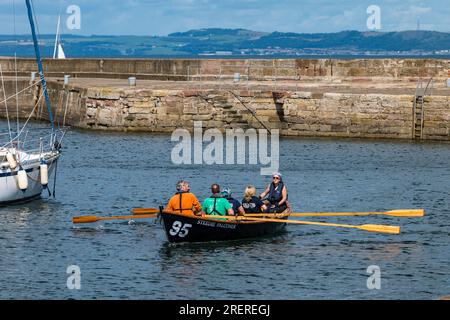 Menschen in St Ayles Ruderboot, Fisherrow Harbour, Musselburgh, East Lothian, Schottland, UK Stockfoto