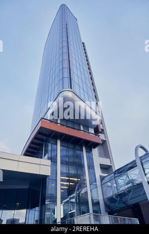 Glasfassaden von Wolkenkratzern an einem hellen, sonnigen Tag am blauen Himmel. Moderne Gebäude im Geschäftsviertel. Wirtschaft, Finanzen, das Konzept des Unternehmertums. Bottom-up-Ansicht. Hochwertiges Foto Stockfoto