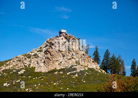 Big Bear City, Kalifornien, USA. 22. Juli 2023. Der Aussichtsturm auf dem Butler Peak hat eine lange und interessante Geschichte. Es wurde 1936 vom Zivilen Schutzkorps erbaut, einem Hilfsprogramm, das junge Männer während der Großen Depression beschäftigte. Der Turm war Teil eines Netzwerks von Feuerwachen, die zur Erkennung und Verhinderung von Waldbränden im San Bernardino National Forest beitrugen. Der Turm ist 14 Fuß x 14 Fuß groß und steht auf einem 10 Fuß hohen Betonboden. Es hat Fenster auf allen vier Seiten und einen Laufsteg, der die Hütte umgibt. Der Turm war bis in die 1970er von Freiwilligen besetzt, als er wegen geschlossen war Stockfoto