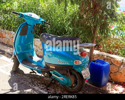Alte blaue Vespa Motorroller, parkt am Straßenrand, Insel Tilos, Dodekanesische Inselgruppe. Griechenland, Juli 2023 Stockfoto