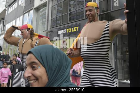 Manchester, Vereinigtes Königreich, 29. Juli 2023. Retro-Rettungsschwimmer mit altmodischen Badeanzügen und Flaggen bieten an, mit Passanten zu posieren, um Fotos und Selfies auf Deansgate neben dem Manchester Airport zu machen. Manchester Day - im Urlaub!, kostenlos, Spaß, familienfreundlich, Veranstaltungen in den Straßen des Stadtzentrums von Manchester, Großbritannien. Unterstützt von Manchester City Council, Manchester Airport Group, Biffa, The Co-op, Manchester Evening News, Wandern Sie auf dem Plank, Kingdom of Sweets, British Firefighter Challenge und Capri Beach Club. Kredit: Terry Waller/Alamy Live News Stockfoto