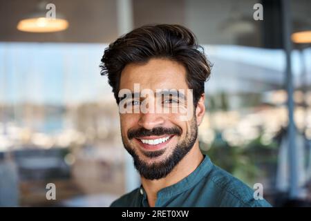 Glücklicher junger lateinischer Geschäftsmann, der in die Kamera schaut, Porträt mit Porträt. Stockfoto