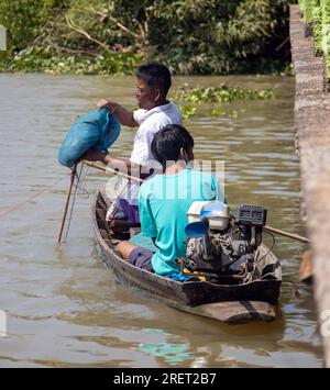 PRACHIN BURI, THAILAND, FEBRUAR 26 2023, Ein Fischer in einem kleinen Boot fängt Fische mit einem Netz Stockfoto