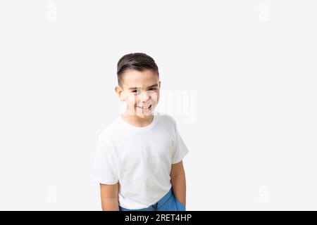 Porträt eines lachenden, weißen osteuropäischen 8 oder 9 Jahre alten Jungen im weißen T-Shirt Stockfoto